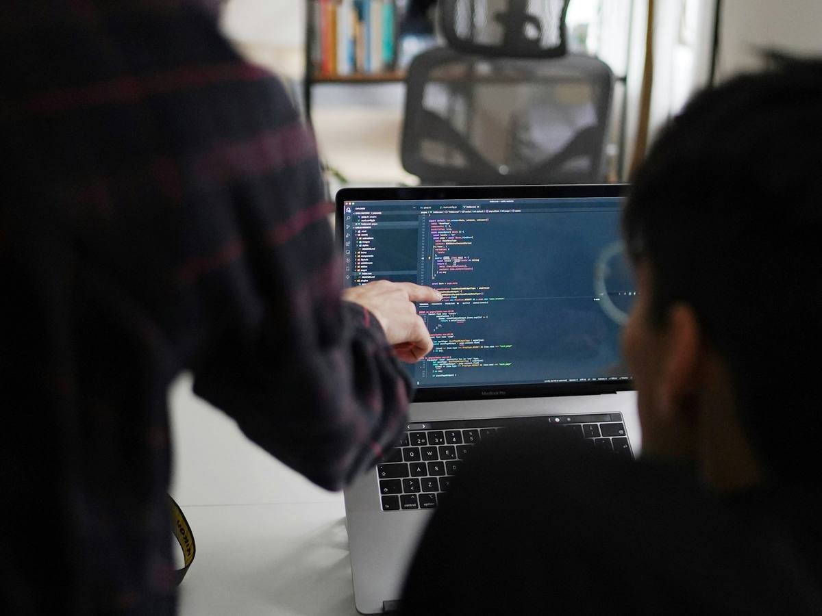 Two engineers reviewing code together at a shared desk
